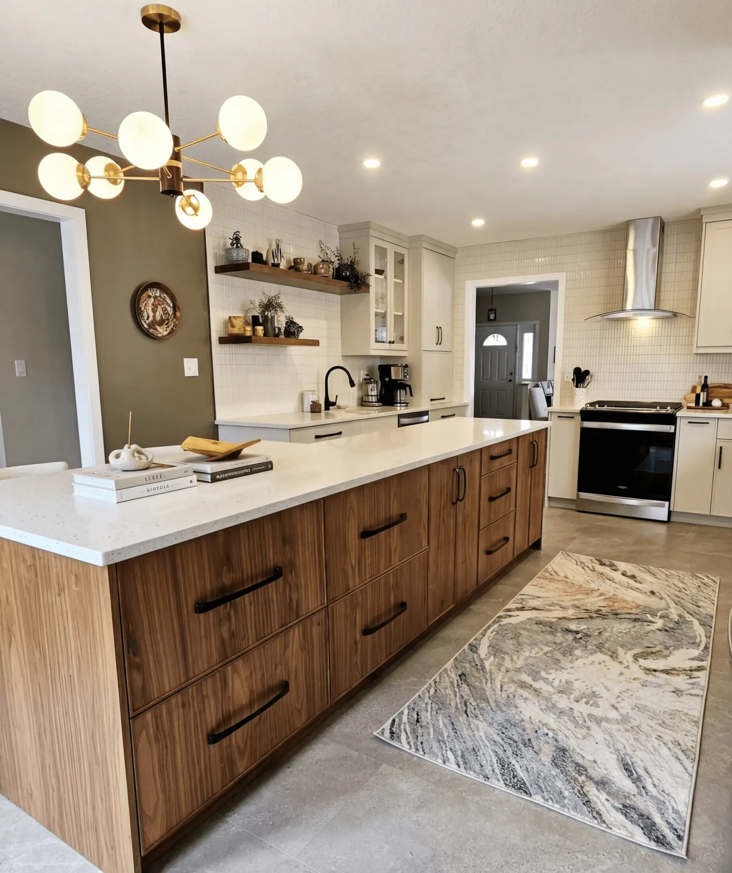 Walnut kitchen island with white cabinetry, open shelving, and warm brass lighting