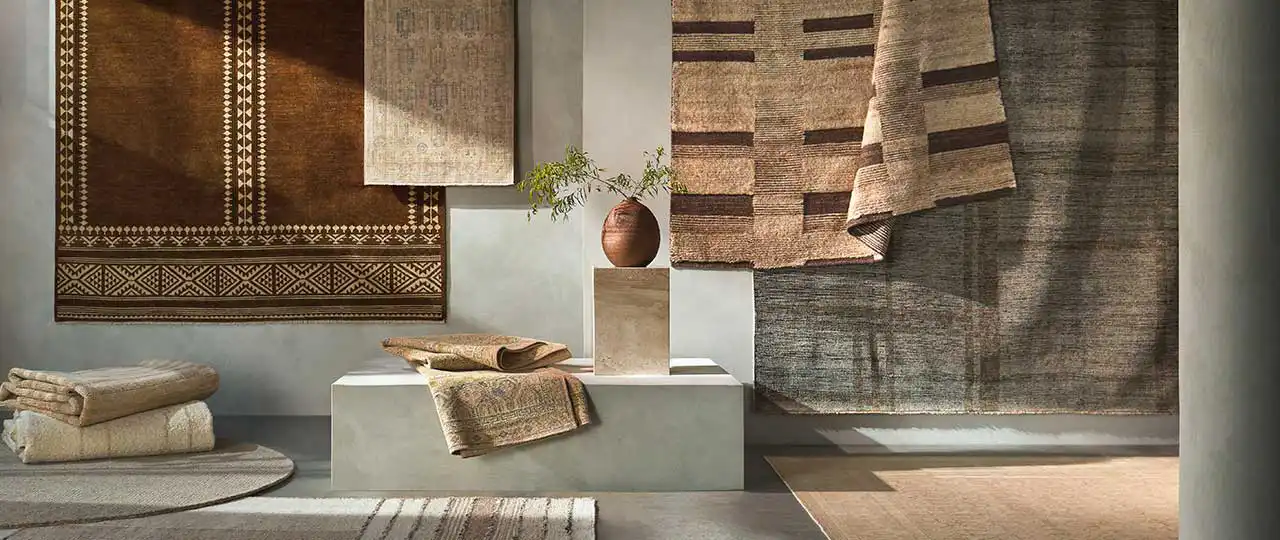 Earth-toned rug display in a layered textile setting