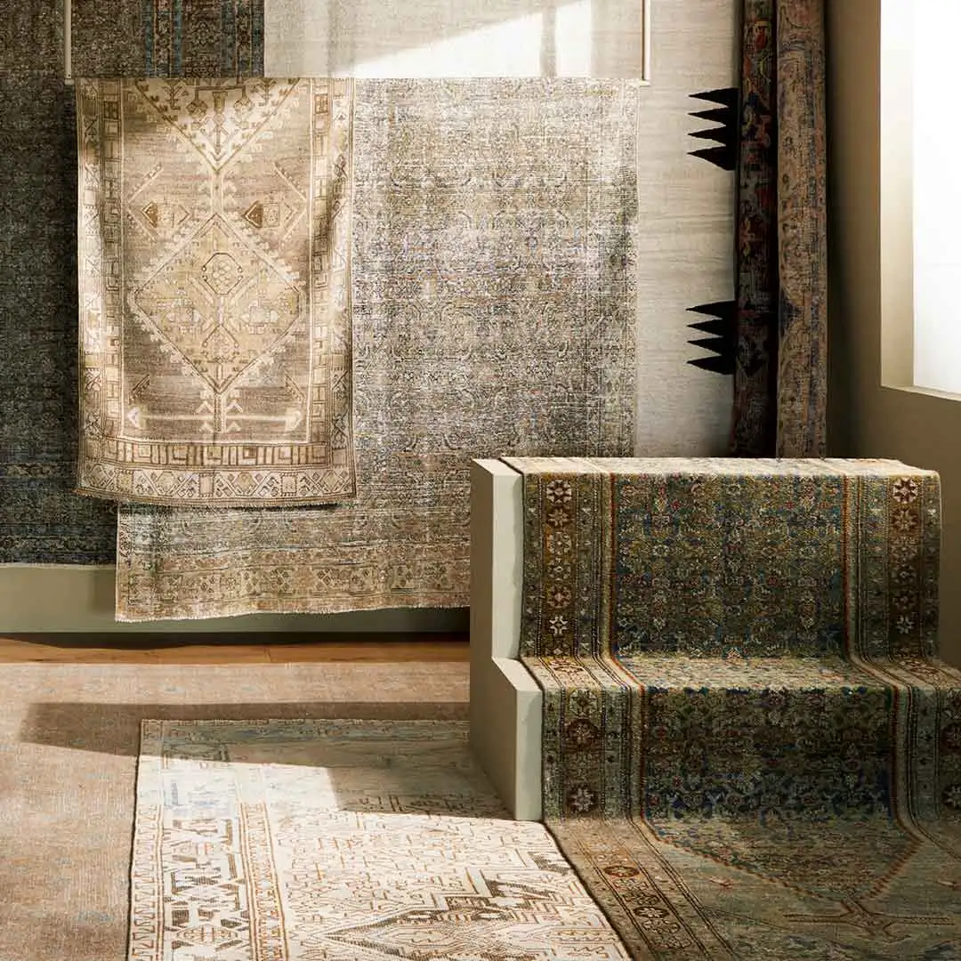 Layered vintage-style rugs displayed in the showroom
